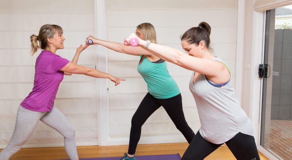 Kirsti Viitala, Pilates instructor assisting two women during Pilates class