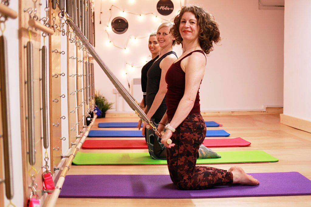 Claire Sparrow, Pilates teacher doing exercises with her clients inside her studio