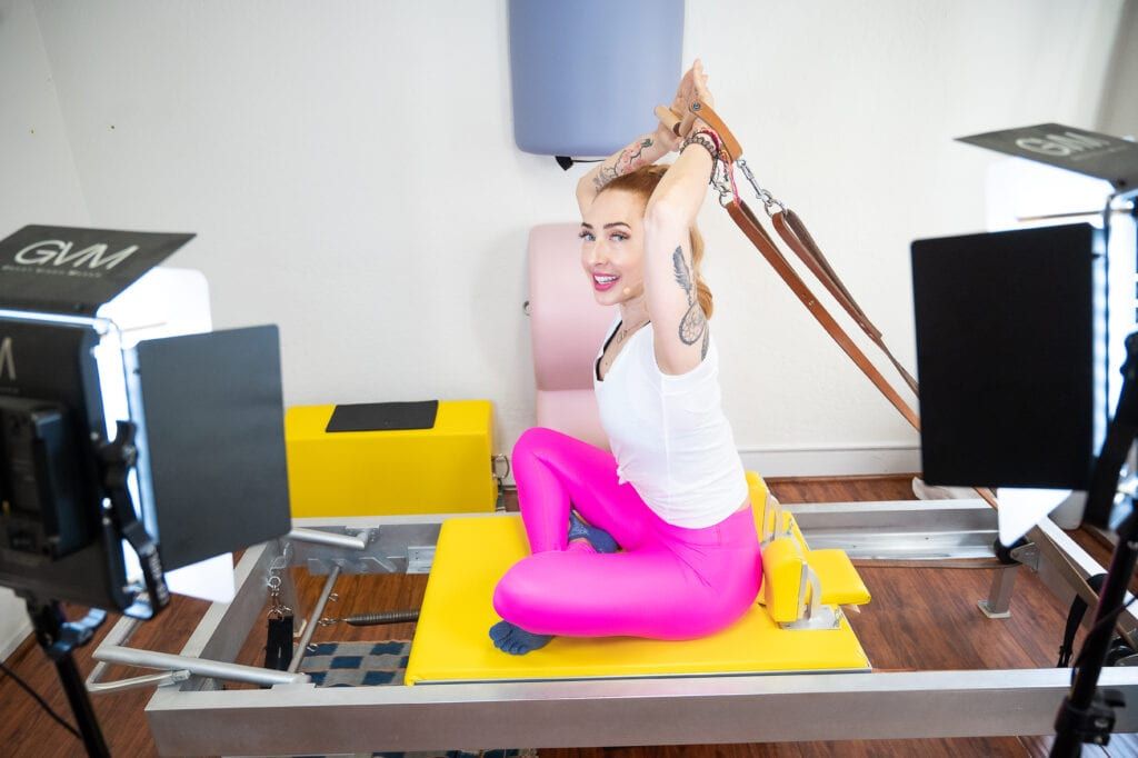 Lesley Logan, Pilates business/studio owner recording reformer workout on her studio in colorful pants