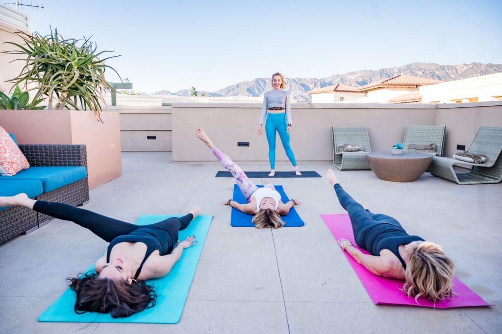 Pilates instructor teaching a group on a rooftop with an amazing view