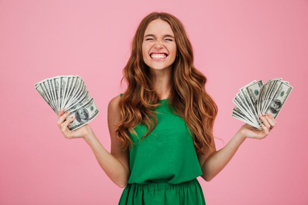 Woman grinning with lots of money in her hands