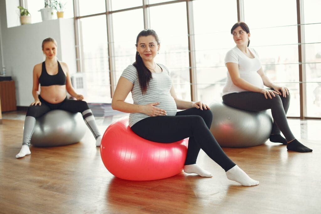 Pregnant women sitting on exercise balls to focus on their transformation into motherhood.