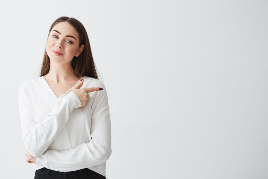 Confident woman wearing white blouse pointing finger
